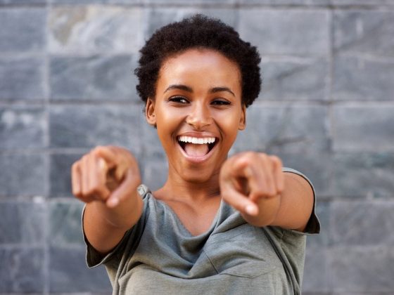 Black woman smiling and pointing